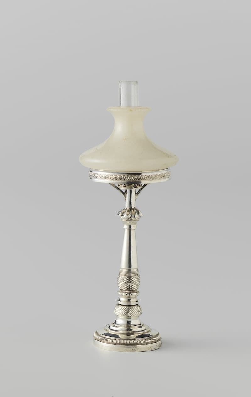 Een hoge, slanke staande lamp met een gedraaide balusterstam op een ronde voet en een opvallend brede stenen kap.